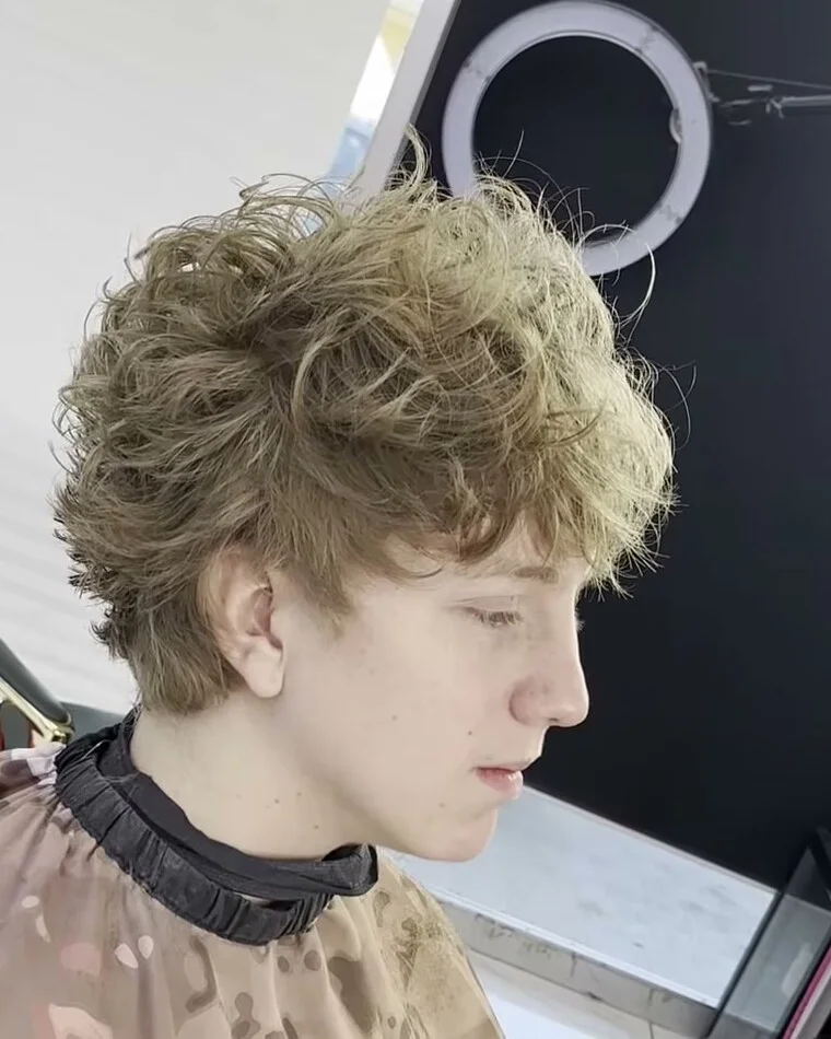 Curly hair shaped with a soft side taper.